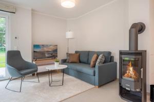 a living room with a couch and a fireplace at Fischerdorf DDH Hafftraum in Zirchow