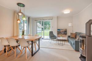 a dining room and living room with a table and chairs at Fischerdorf DDH Hafftraum in Zirchow