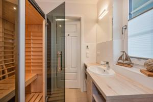 a bathroom with a sink and a glass shower at Fischerdorf DDH Hafftraum in Zirchow +18 photos