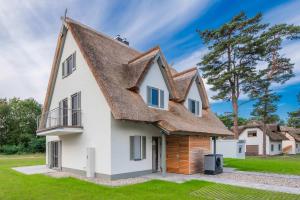 an old house with a thatched roof at Fischerdorf DDH Hafftraum in Zirchow