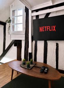anetflix sign on a wall in a room with a table at Duplex Charme & Fleurs, vue Cathédrale in Chartres