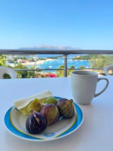 a plate of figs on a table with a coffee cup at Vila Athina in Ksamil
