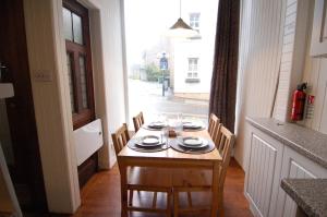 a table with chairs and plates on top of it at Baker Street Retreat in Stirling +4 photos
