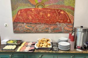 a buffet with food and a painting on the wall at DOKK Agárd in Gárdony