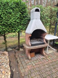 a outdoor oven with a bench next to a fence at Kamińsko 640 - Puszcza Zielonka in Kamińsko