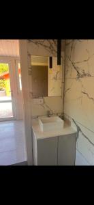 a bathroom with a sink and a marble wall at domek 3 osoobowy in Augustów +1 photo