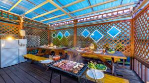 a kitchen with wooden tables and a refrigerator in a pavilion at Suncheonman Muhan Dojan Pension in Suncheon