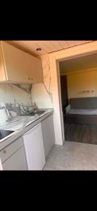 a small kitchen with a sink and a bed in it at domek 3 osoobowy in Augustów