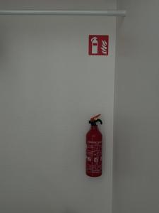 a red fire extinguisher is on a wall at Modern private Rooms with attached Bathroom & Free Parking in Bruges
