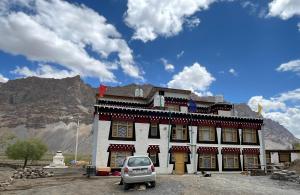 a car parked in front of a building with a mountain at The Norbu Retreat Hull in Kaza
