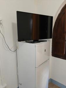 ein Flachbildfernseher auf einem Kühlschrank in der Unterkunft Ikenga in Castellón de la Plana