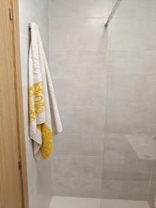 ein Badezimmer mit Dusche und Handtüchern an der Wand in der Unterkunft Ikenga in Castellón de la Plana
