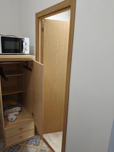 eine Tür zu einem Schrank mit Spiegel und Mikrowelle in der Unterkunft Ikenga in Castellón de la Plana + 1 Foto