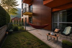 eine Hängematte auf dem Balkon eines Gebäudes in der Unterkunft Wise Nest Studio with pool and spa in Sinaia + 18 Fotos