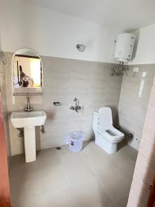 a bathroom with a sink and a toilet and a mirror at The Norbu Retreat Hull in Kaza