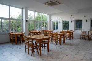 a dining room with tables and chairs and windows at Karma homes in Turunç