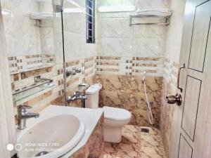 a bathroom with a toilet and a sink at Hotel Royal Avenue in Chittagong