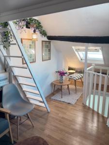 a staircase in a living room with a table and chairs at Duplex Charme & Fleurs, vue Cathédrale in Chartres