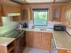 a kitchen with wooden cabinets and a sink and a window at Retro Mobilhome in Igal +2 photos