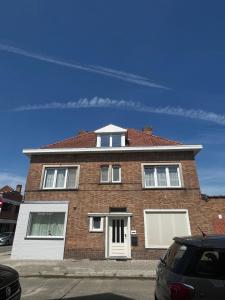 a brick house with white doors and a car parked in front at Modern private Rooms with attached Bathroom & Free Parking in Bruges