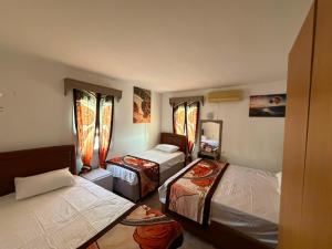 a room with three beds in it with windows at CİELO Otel in Bodrum City