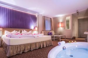 Cette chambre comprend deux lits et une baignoire. dans l'établissement Alpen-Herz Romantik & Spa - Adults Only, à Ladis