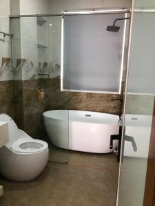 a bathroom with a toilet and a glass shower at Villa SeriGold - NovaWorld Phan Thiết in Tiến Thành