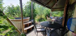 a screened in porch with a table and a tub at Tent Ween at Glamping Verbaarum in Bedum