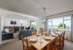 a dining room with a table and a living room at Boskenna in Tintagel