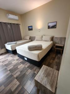 a bedroom with two beds and a table at Hotel Boutique Porá Iguazú in Puerto Iguazú +79 photos