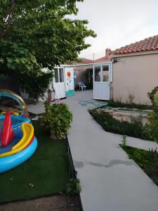 a backyard with a play equipment on a lawn at Lilly of Lemnos in Roussopoúlion