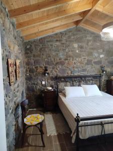 a bedroom with a bed and a stone wall at Lilly of Lemnos in Roussopoúlion +26 photos