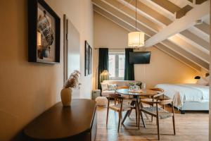 a living room with a bed and a table and chairs at MANA LISA Boutiquehotel in Lauda-Königshofen