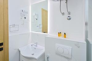 a white bathroom with a sink and a mirror at FourMountains-Bjelašnica in Sarajevo +10 photos