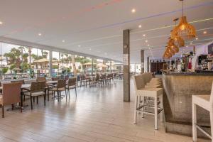 a restaurant with a bar and tables and chairs at Ona Las Brisas in Playa Blanca
