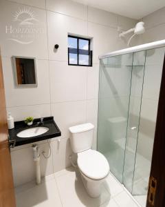 a bathroom with a toilet and a shower and a sink at Pousada Horizontes de Bonito in Bonito