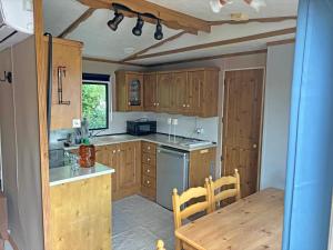 a kitchen with wooden cabinets and a wooden table and a table and a dining room at Retro Mobilhome in Igal