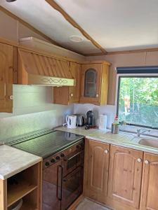 a small kitchen with wooden cabinets and a window at Retro Mobilhome in Igal