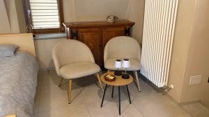 two chairs and a side table in a bedroom at Il cortile in Boves