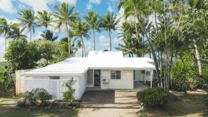 a white house in front of palm trees at Suva Point Ocean Front Nukulau Island Views in Suva