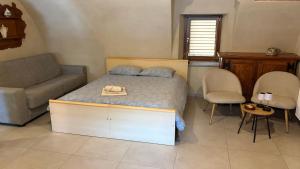 a bedroom with a bed and a couch and chairs at Il cortile in Boves