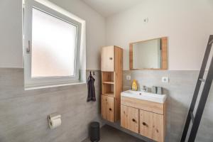 a bathroom with a sink and a mirror at Haus Redi in Sasbach in der Ortenau +42 photos
