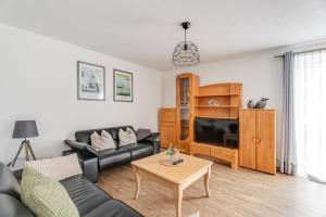 a living room with a couch and a tv at Haus Redi in Sasbach in der Ortenau