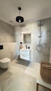 a white bathroom with a sink and a toilet at Apartamenty ORION Trzęsacz in Trzęsacz +35 photos