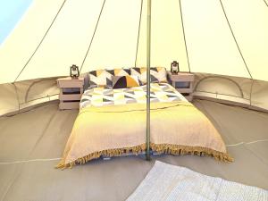 a bed in a tent on a yacht at West Holme Glamping in Wareham