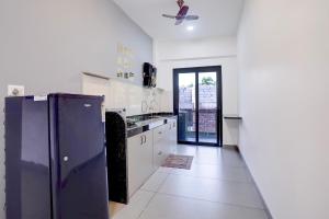 a large white kitchen with a refrigerator and a door at FabHotel Casa Mandrem in Mandrem +55 photos