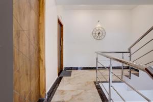 a hallway with stairs and a clock on the wall at FabHotel Casa Mandrem in Mandrem