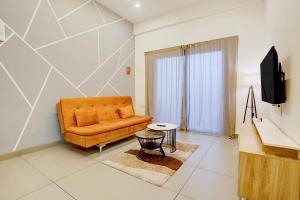 a living room with a couch and a television at FabHotel Casa Mandrem in Mandrem