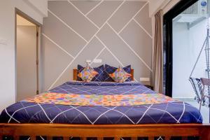 a bedroom with a bed with a blue comforter at FabHotel Casa Mandrem in Mandrem