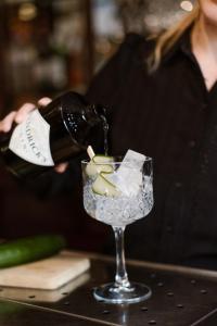 a woman pouring a bottle of wine into a glass at Stadspaleis Hotel & Restaurant OldRuitenborgh in Vollenhove +13 photos